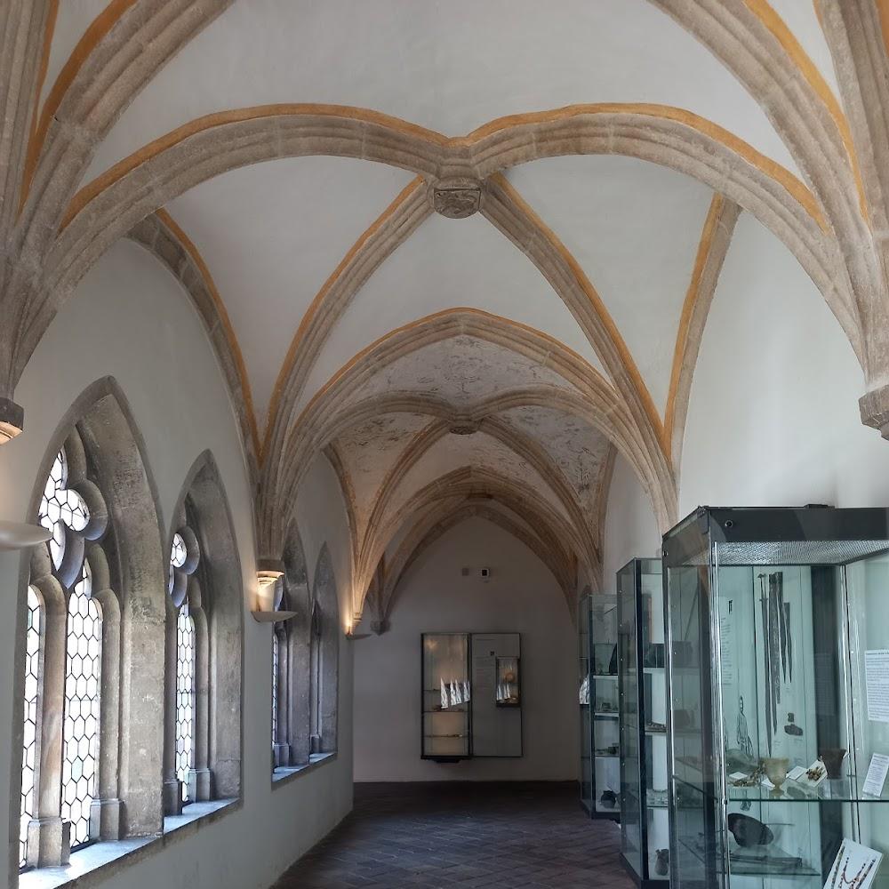 Stone hallway with vaulted ceiling and display cases.